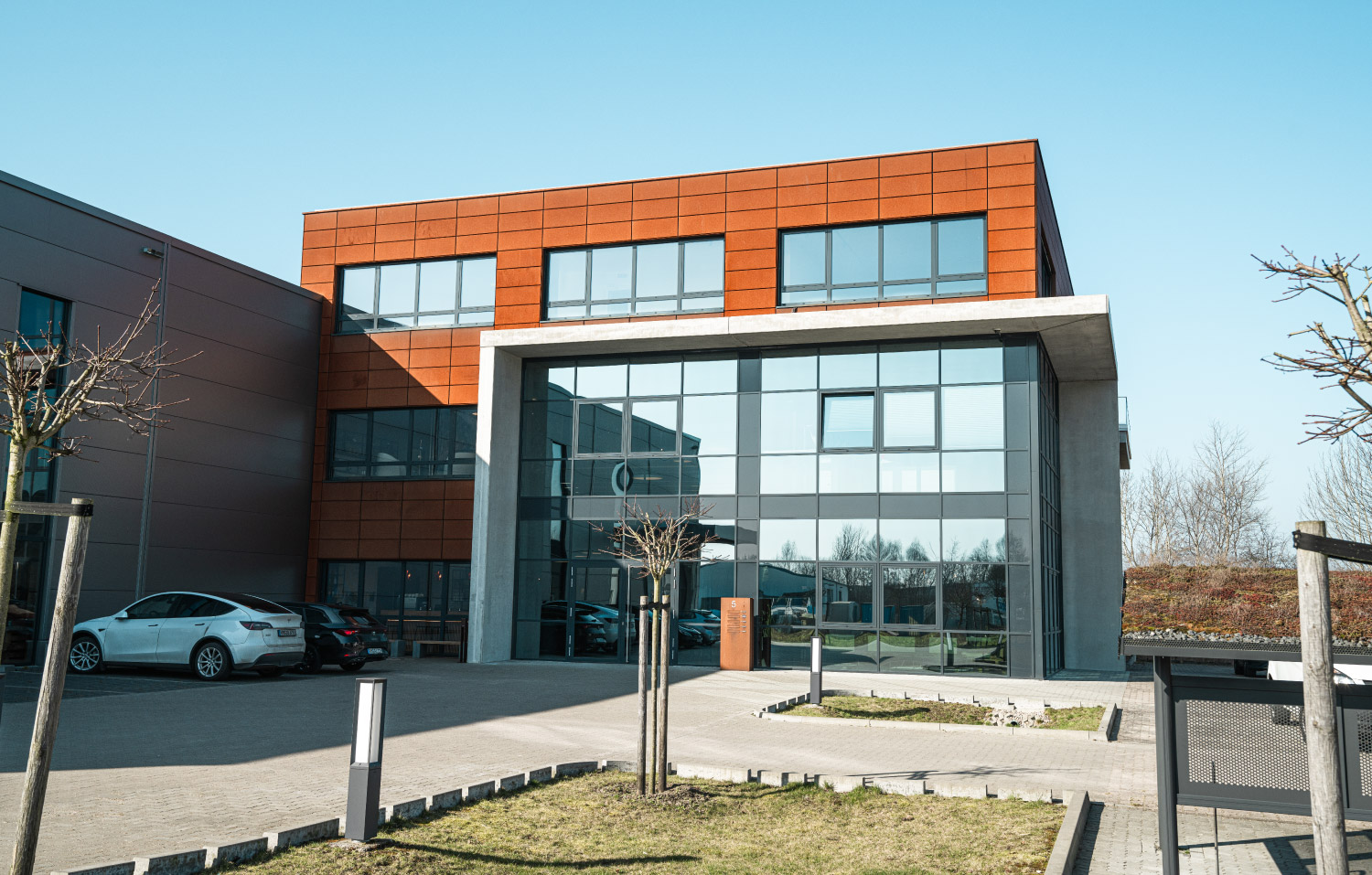 Ansicht eines Bürogebäudes mit parkenden Autos davor