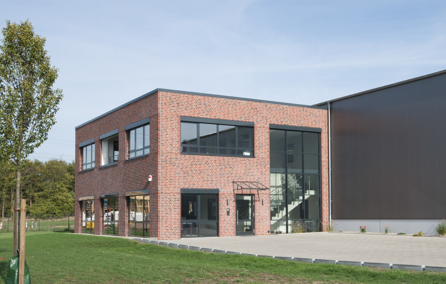 Ansicht eines Bürogebäudes mit parkenden Autos davor