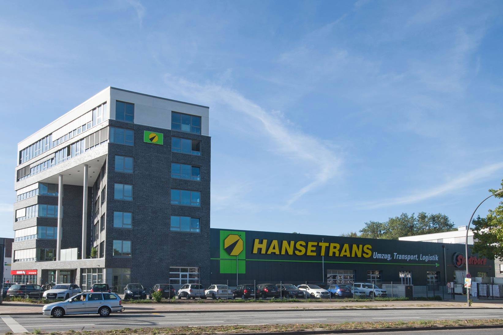 Parkplatz mit einem Gebäude im Hintergrund, das Büro-, Produktions- und Lagerflächen bietet.