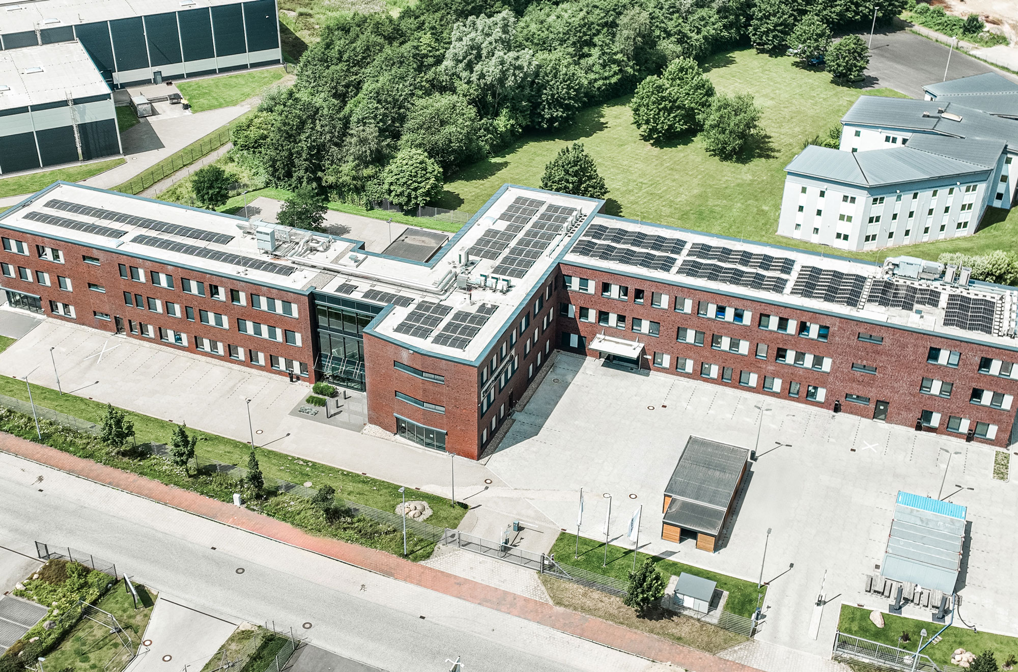 Zwei geschossiges Bürogebäude eines IT-Unternehmens mit grünen Streifen an der Fassade.