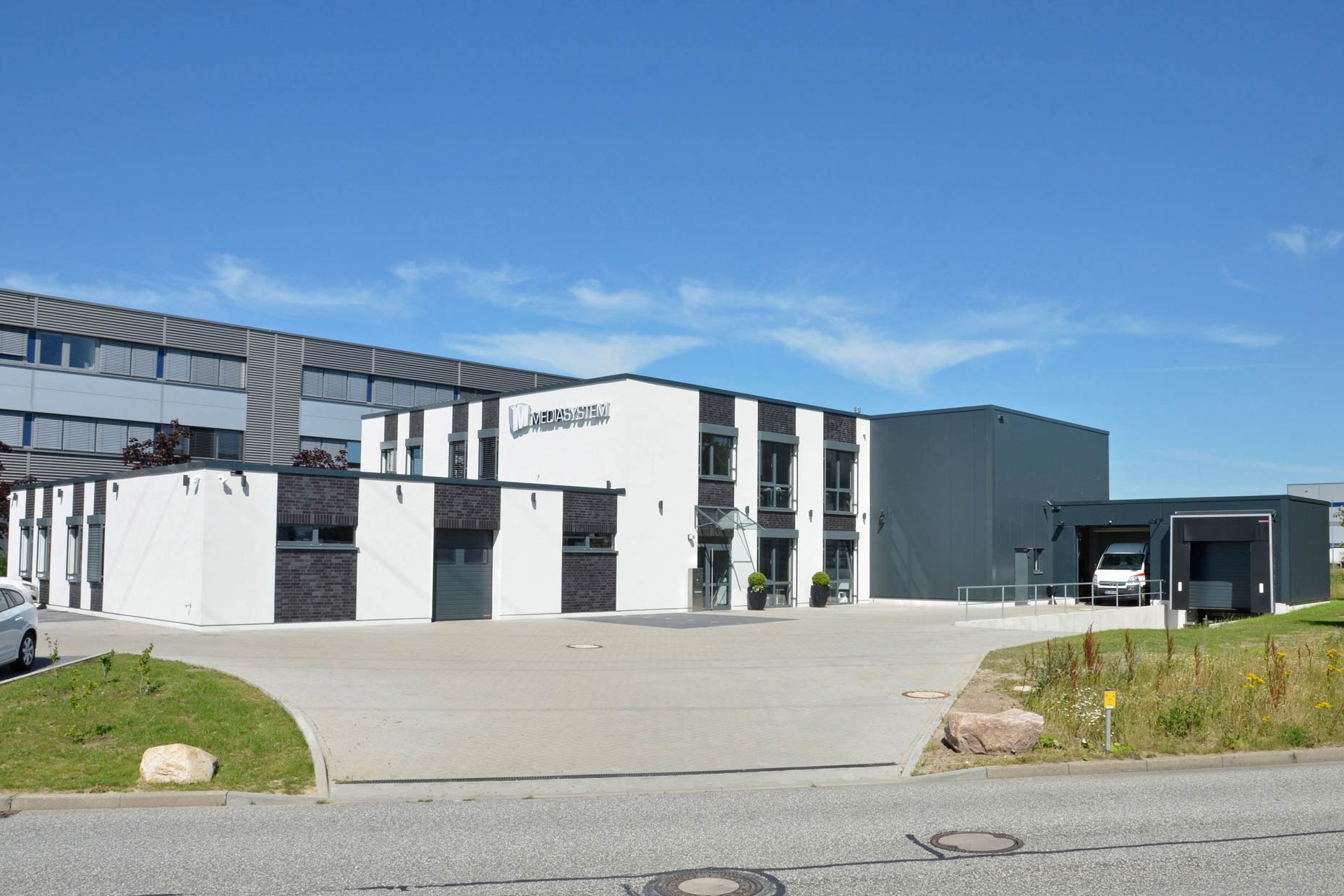 Großes Betriebsgebäude von Speidel mit einer großen Garagentür, spezialisiert auf Brand- und Feuchteschäden.