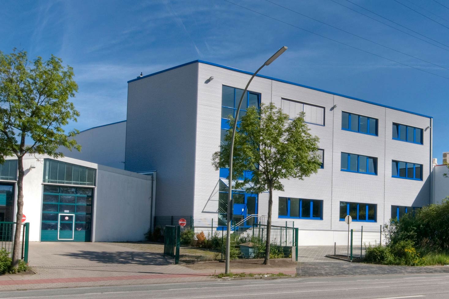 Großes Betriebsgebäude von Speidel mit einer großen Garagentür, spezialisiert auf Brand- und Feuchteschäden.