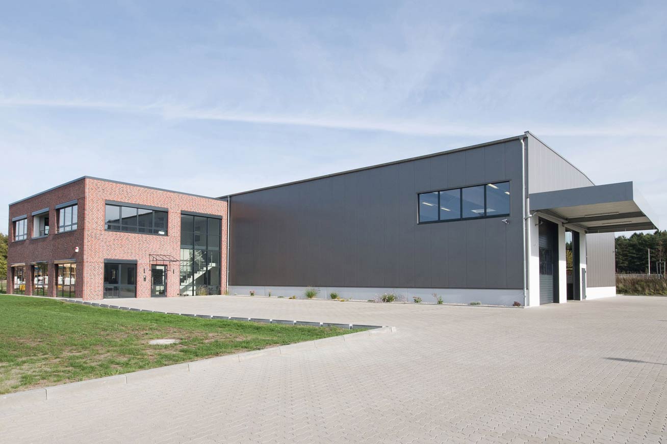 Großes Betriebsgebäude für pharmazeutischen Großhandel mit Parkplatz und Grünflächen.
