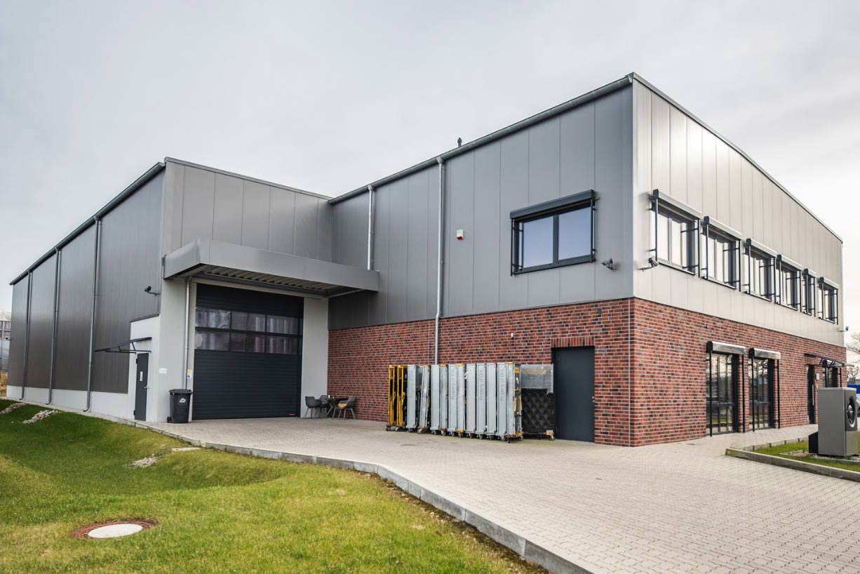 Großes Industriegebäude mit einer großen Garagentür, Erweiterung und Neubau für pharmazeutischen Großhandel.