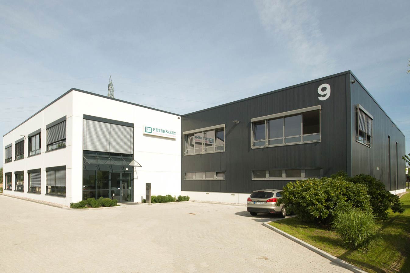 Betriebsgebäude eines Schiffsausrüster-Unternehmens, vor dem ein Auto abgestellt ist.