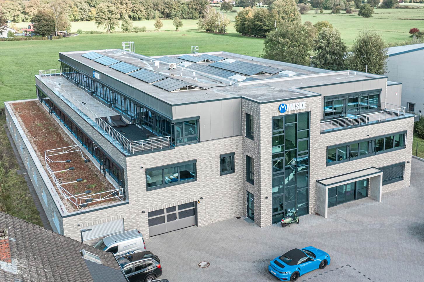 Zwei geschossiges Bürogebäude eines IT-Unternehmens mit grünen Streifen an der Fassade.