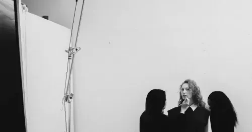 Makeup artist touching up model during commercial photography photoshoot