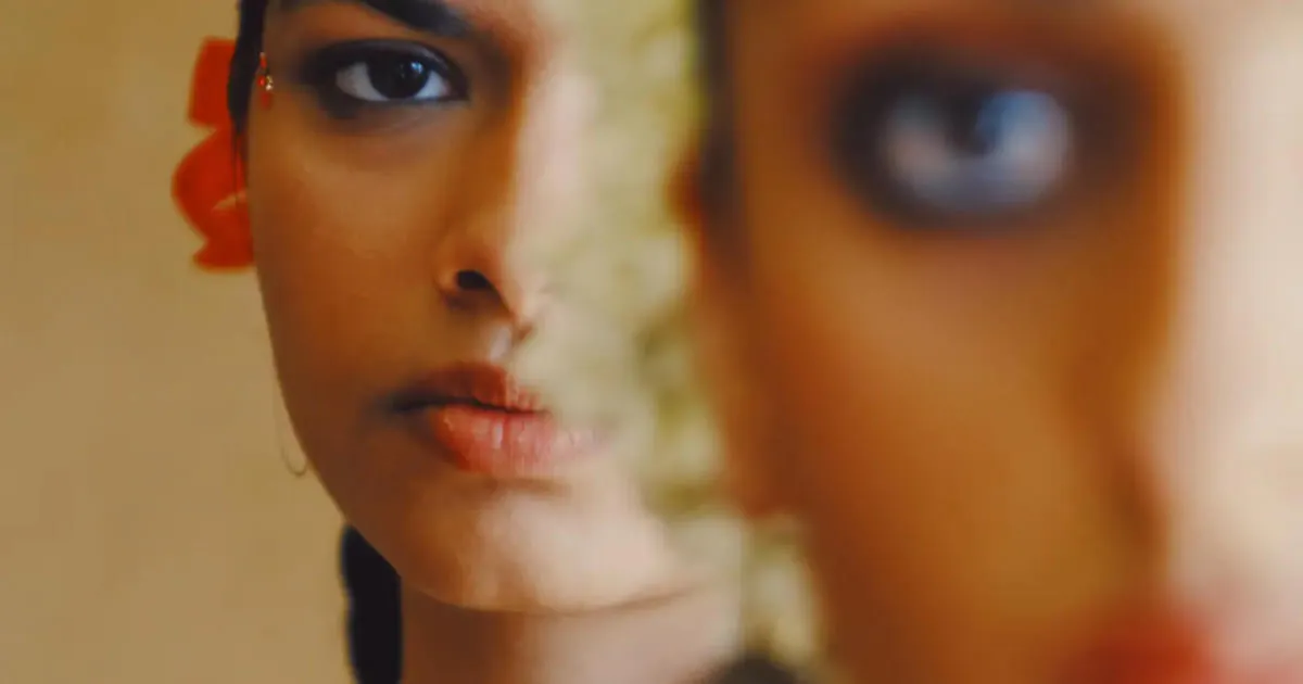 Portrait of a woman behind the blurred face of another woman edited with VSCO app