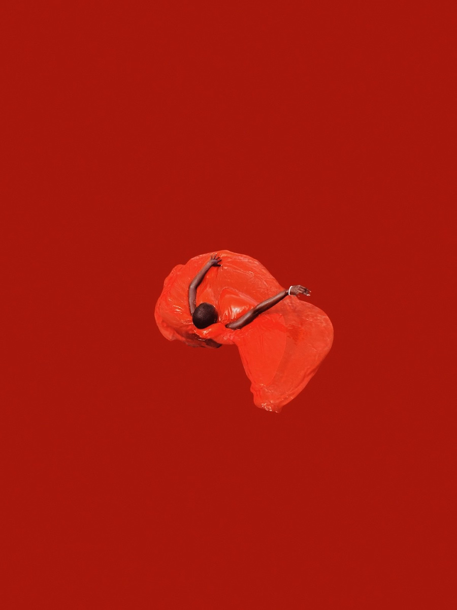Aerial view of someone twirling in a red dress with a solid red background by John Baloy