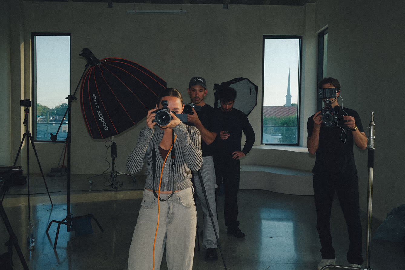 Working photographer on photoshoot set looking through a camera