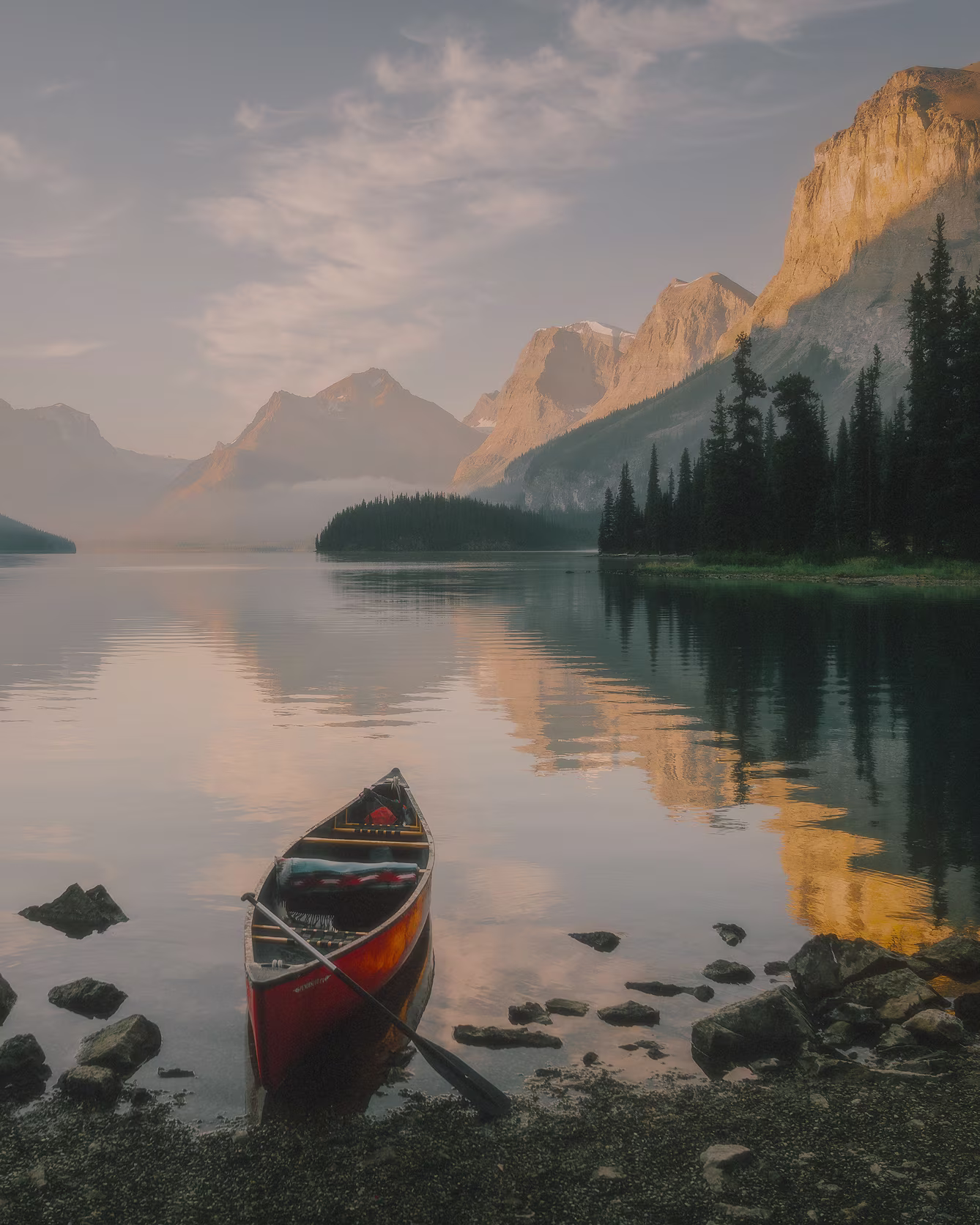 Lifestyle campaign photo of canoe on a still water cold mountain lake