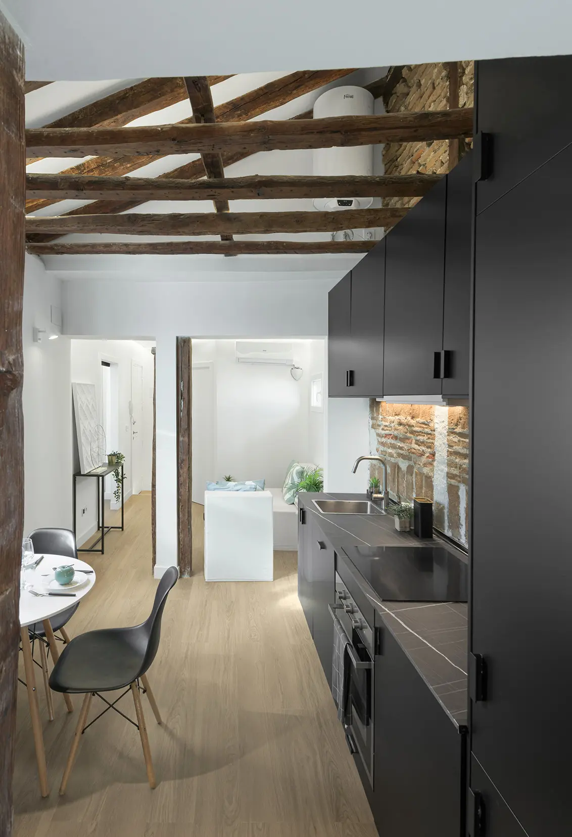 Cocina con vigas de madera vistas y muebles negros mate