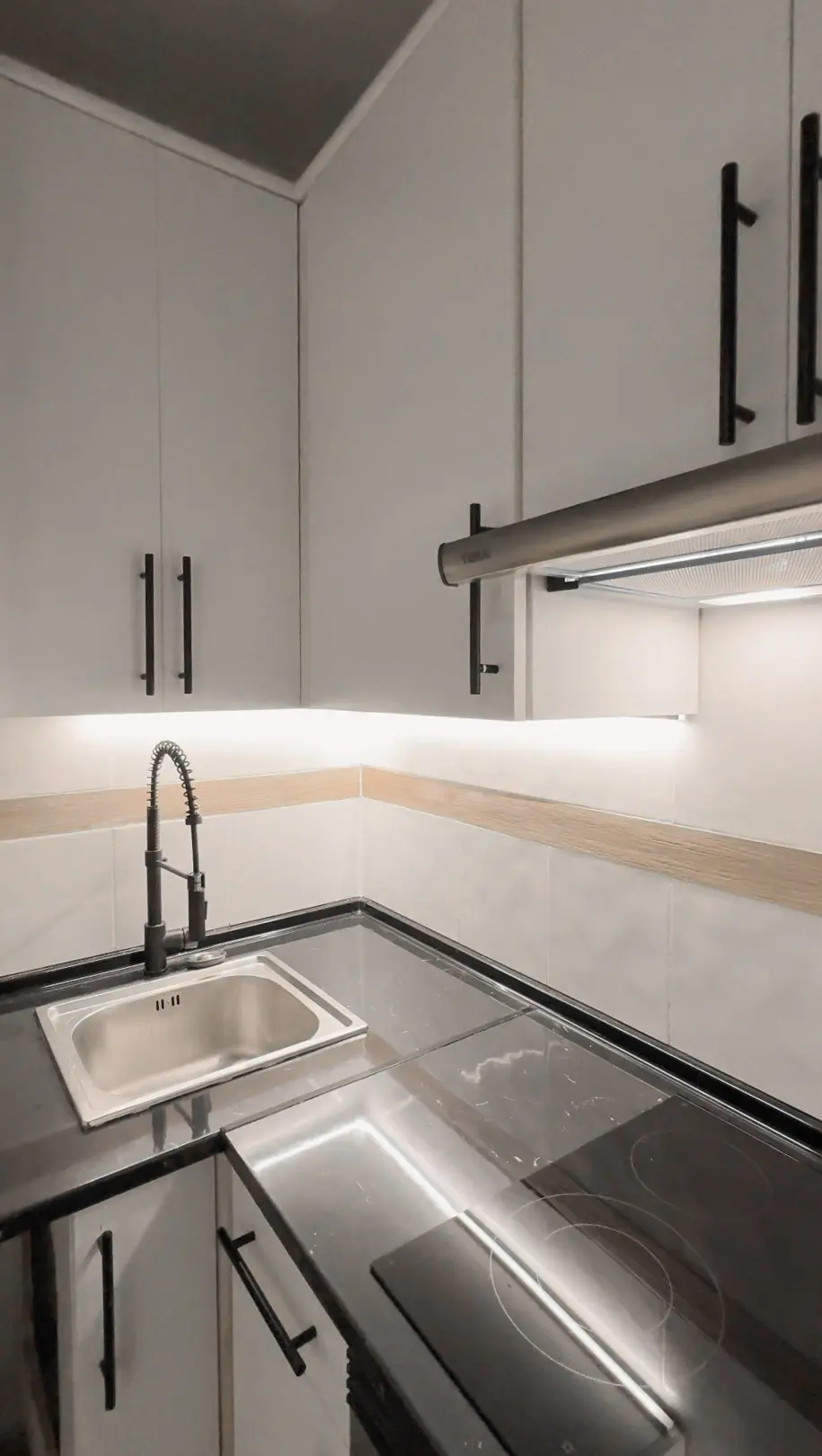 Cocina negra con isla central e iluminación integrada