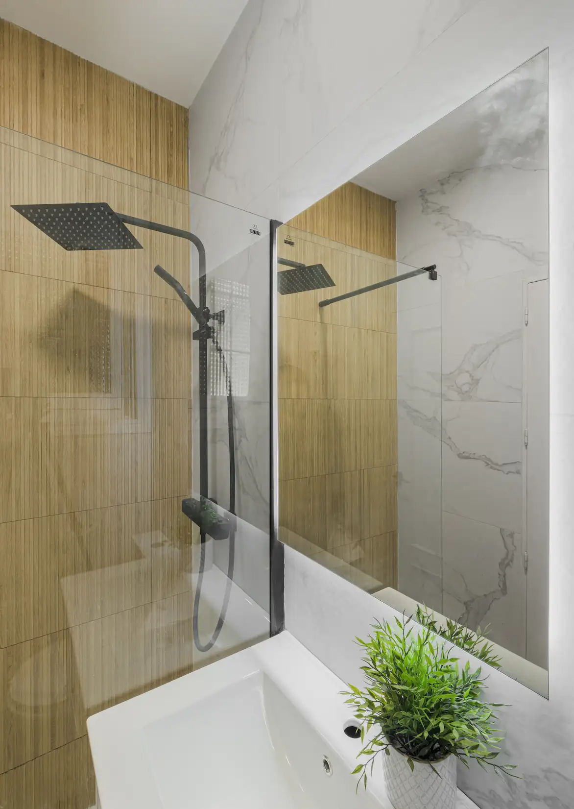 Baño con ducha efecto lluvia y panelado de madera