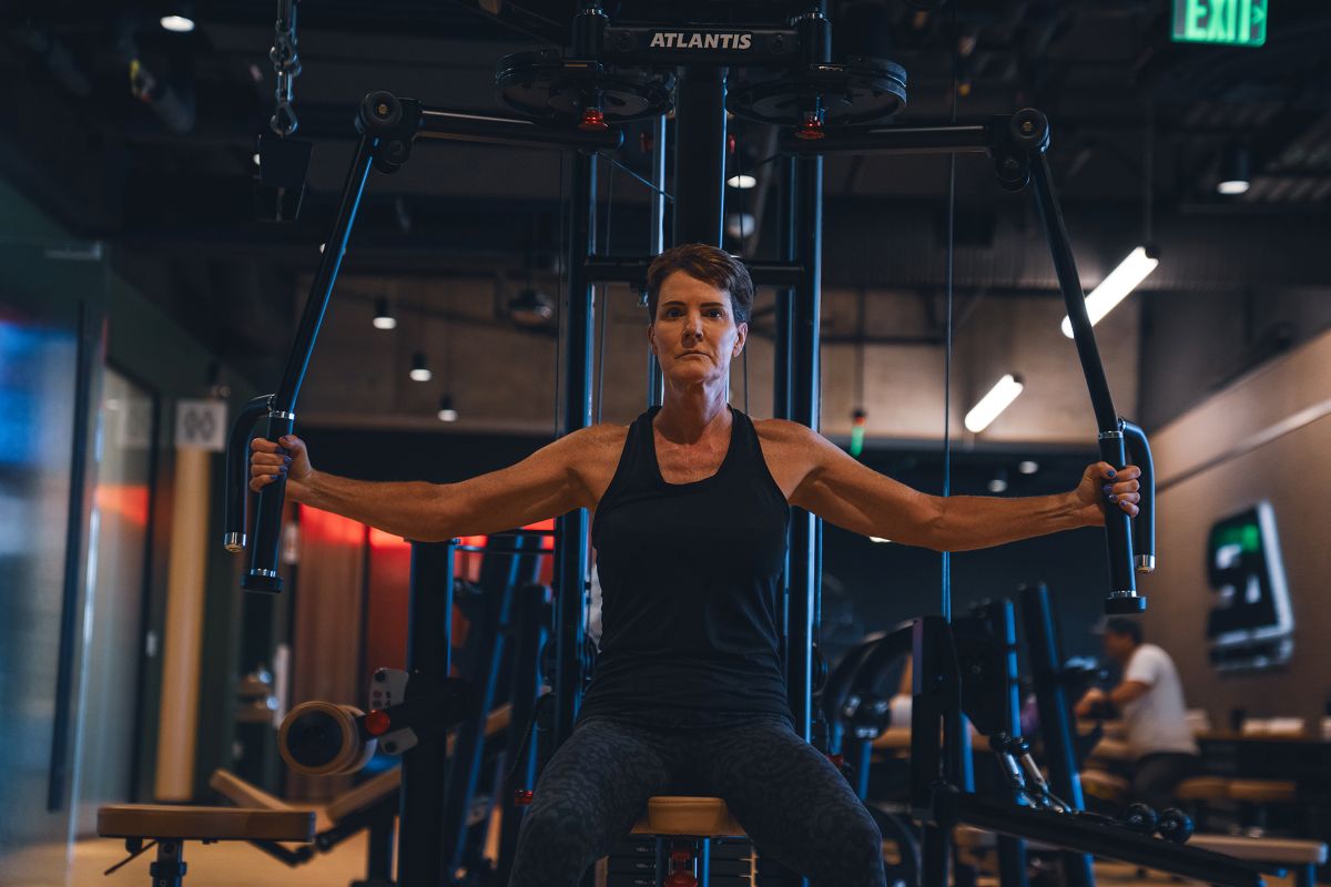 woman using chest fly machine
