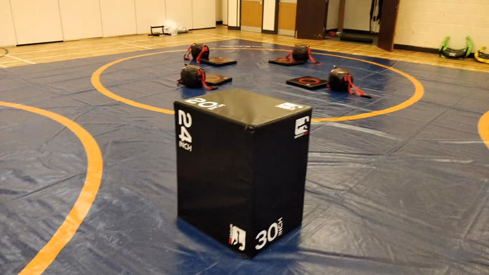 Black box on top of a wrestling mat.