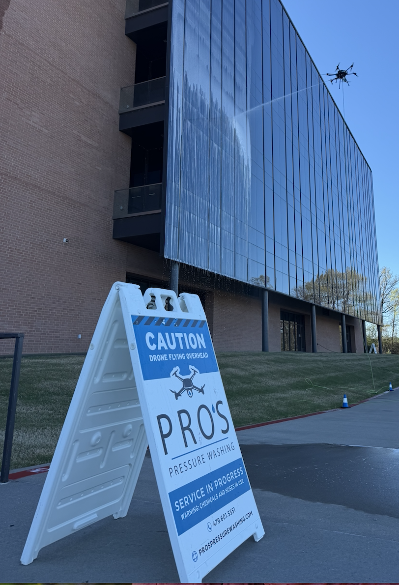 Caution sign reading Drone Flying Overhead posted at a Pro's Pressure Washing jobsite
