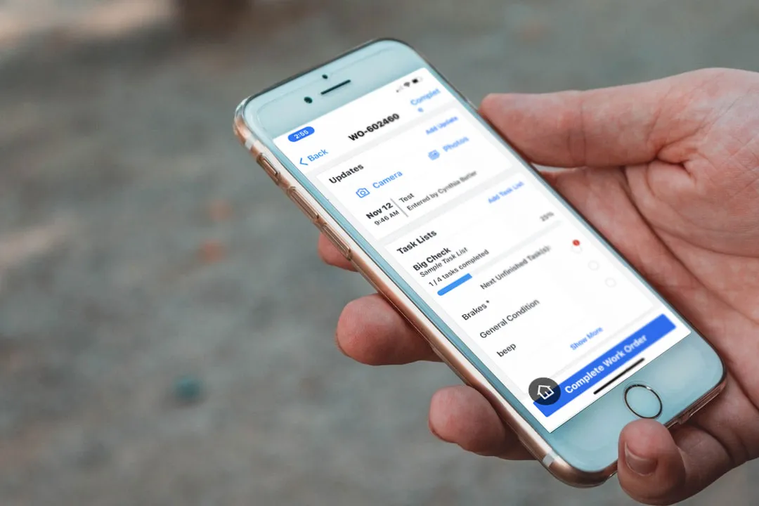 hand holding smart phone with work orders screen displaying.