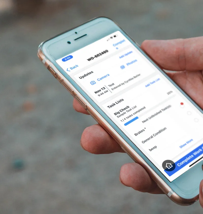 hand holding smart phone with work orders screen displaying.