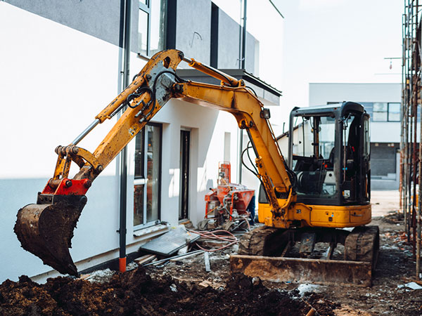 mini excavator working in tight space at jobsite