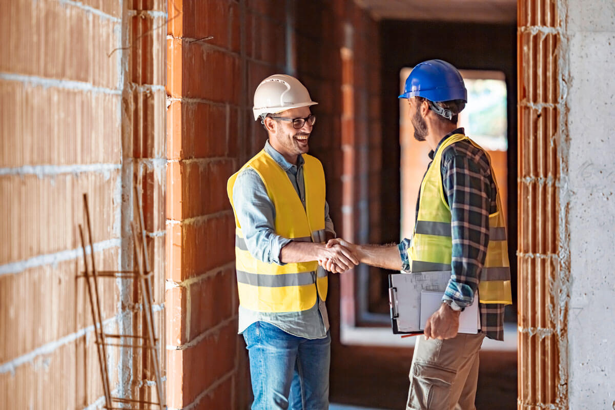Two men shaking ands at a jobsite.