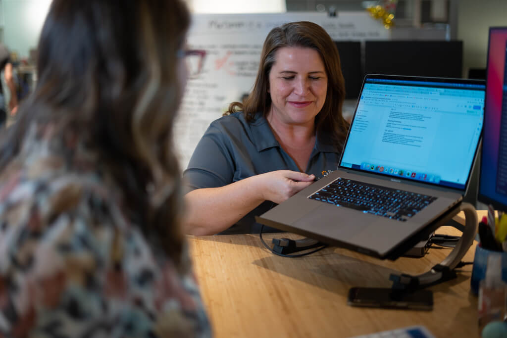 A woman setting up a workstation for another EquipmentShare employee.