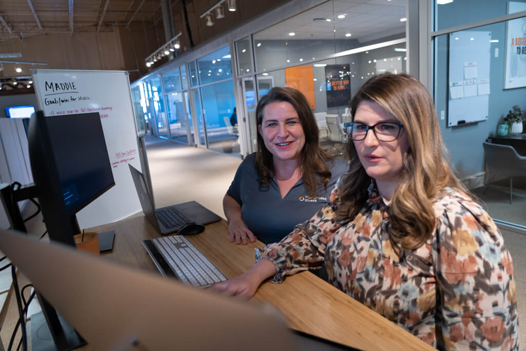 Two women working on a computer.
