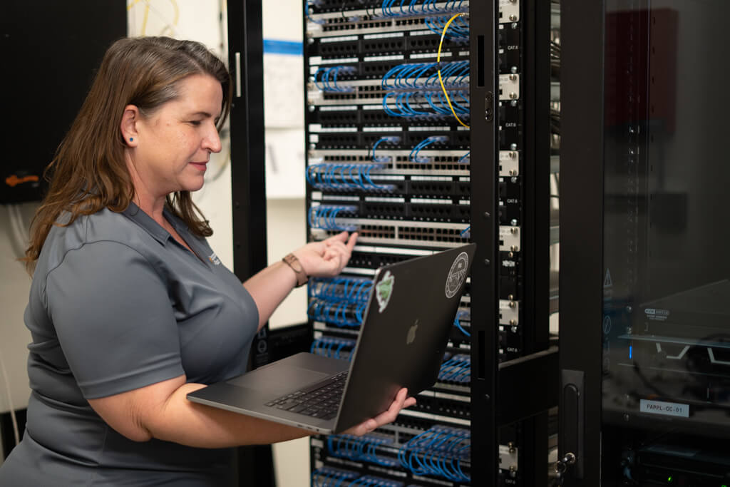 woman working on a batch of servers.