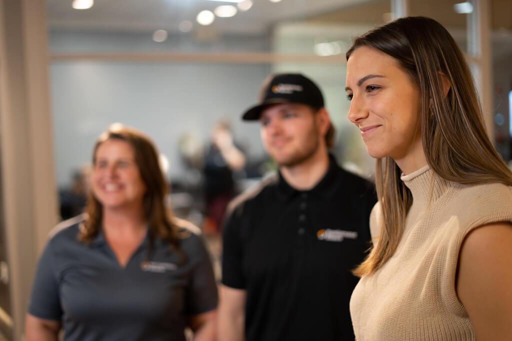 EquipmentShare employees looking at something out of frame and smiling