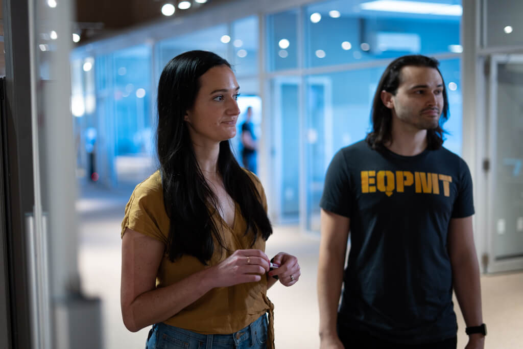 Two Equipmentshare employees talking and looking towards something out of frame.