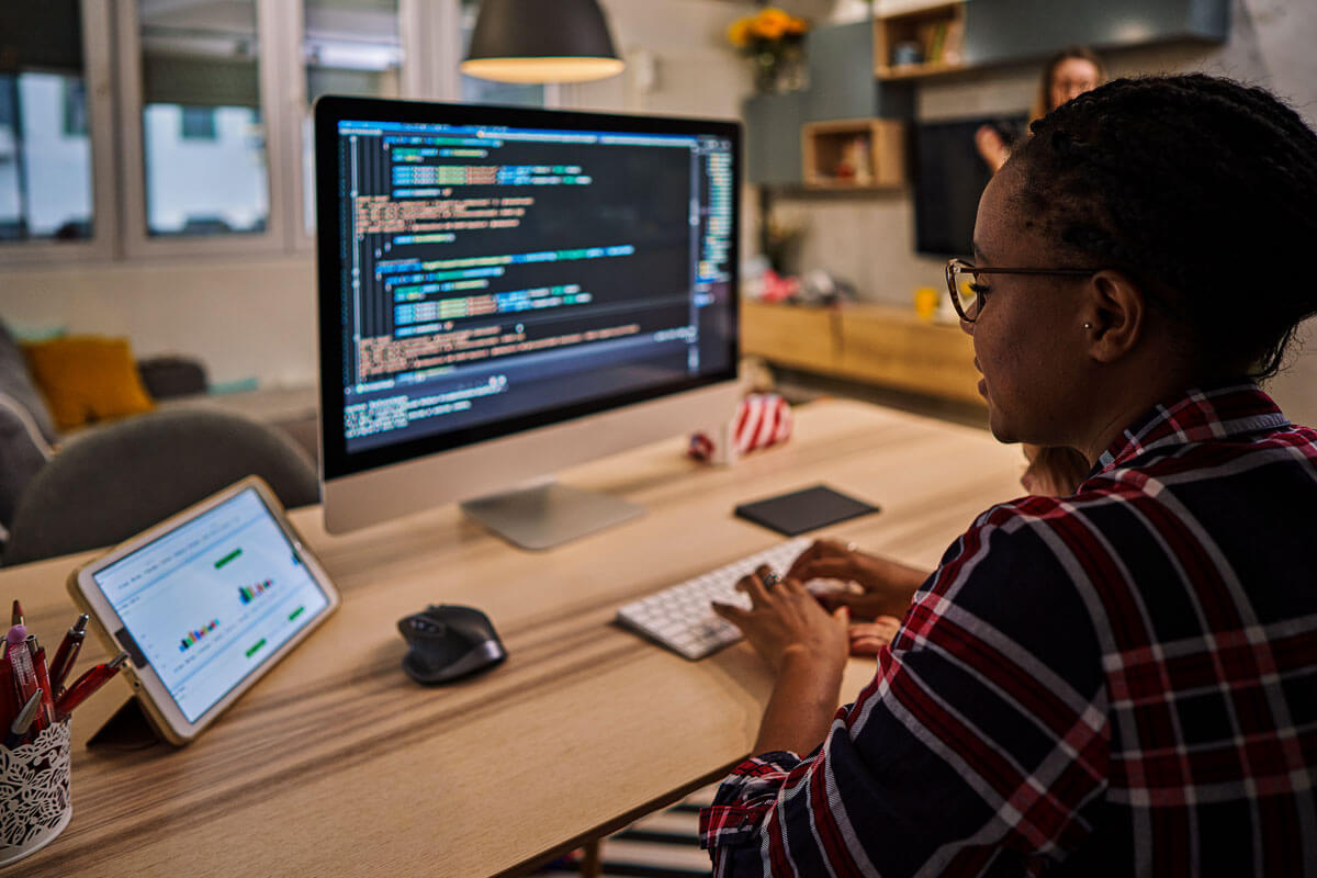 Woman working on code on her computer