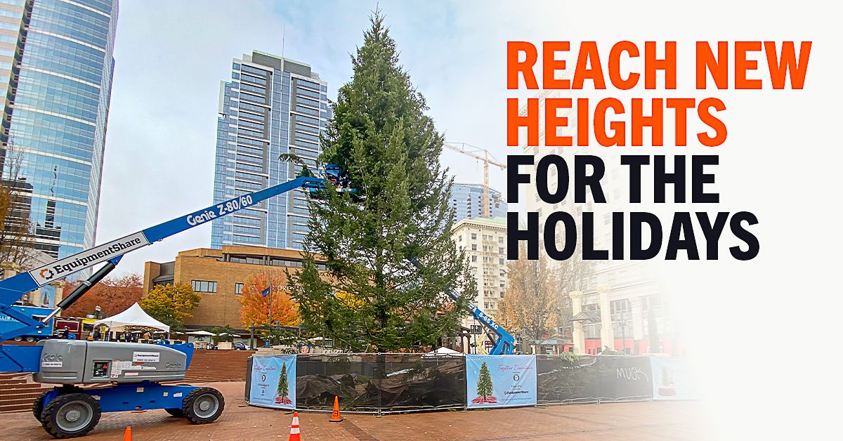 Boom lifts in front of large Christmas tree