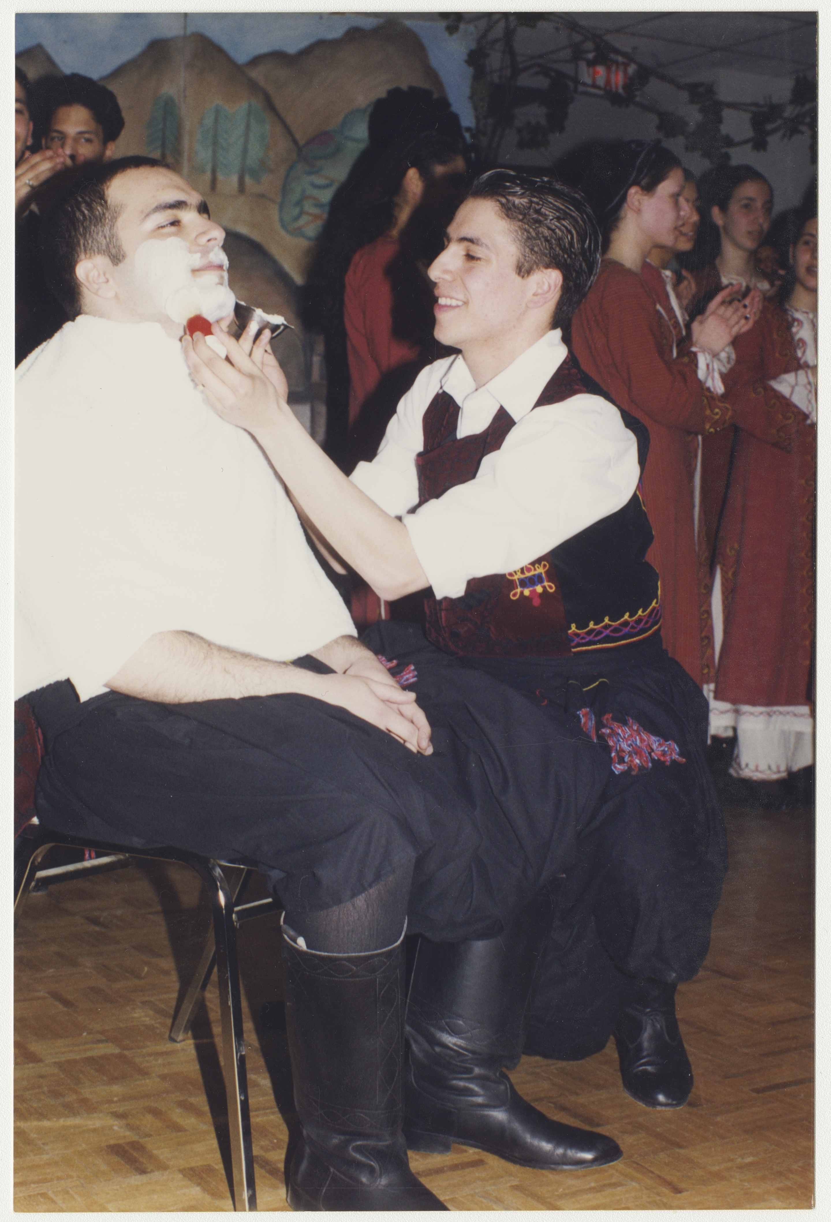 Anna's brother (the one being shaved) with the Cypriot dance group, late 1990s. York University Libraries, ASC61624