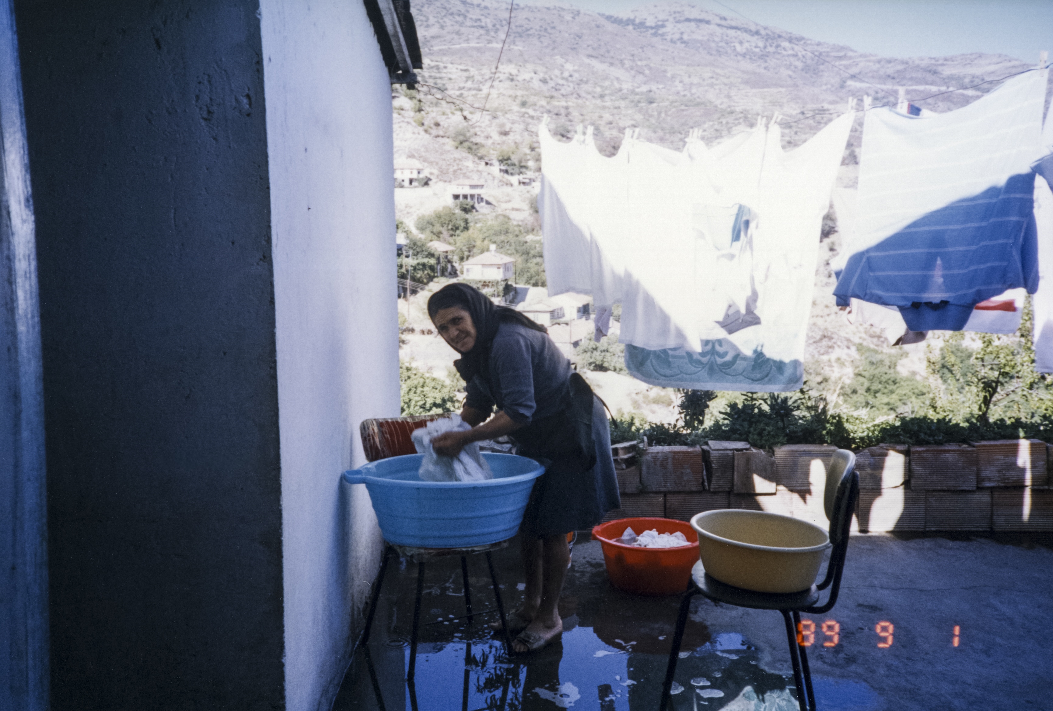 Theodoros' mother washing her clothes outside of her home, September 1, 1989