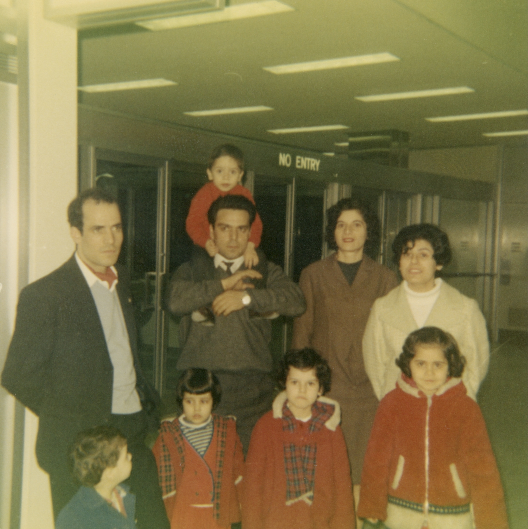 Theodoros with his wife, kids, and extended family waiting at the airport for family members from Cyprus to arrive, late 1960s or early 1970s