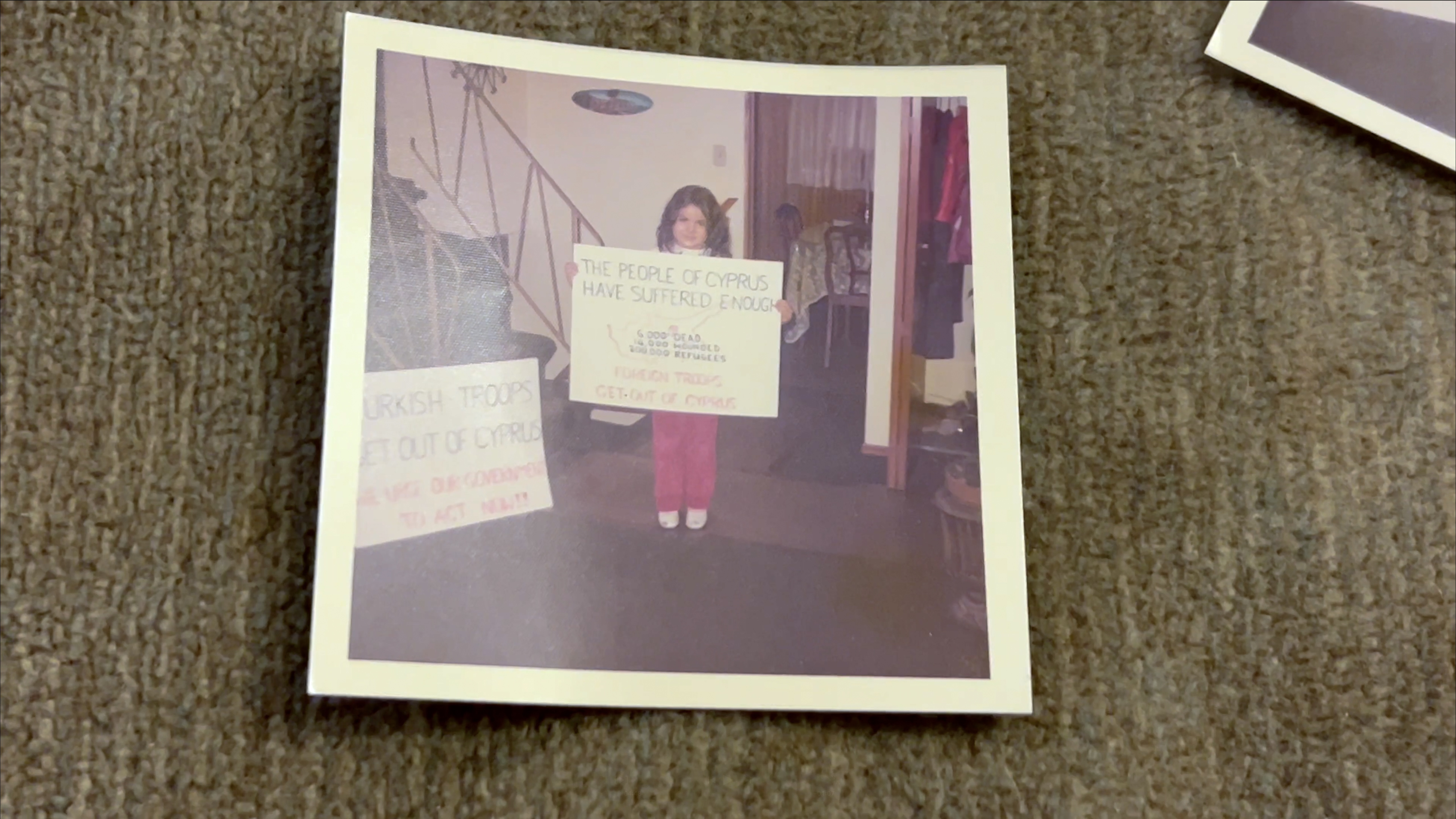 One of Androula's daughters holding a sign made by her parents, getting ready to go to Ottawa to protest the Turkish invasion, 1974