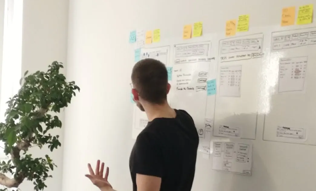 Man pointing at board with sticky notes