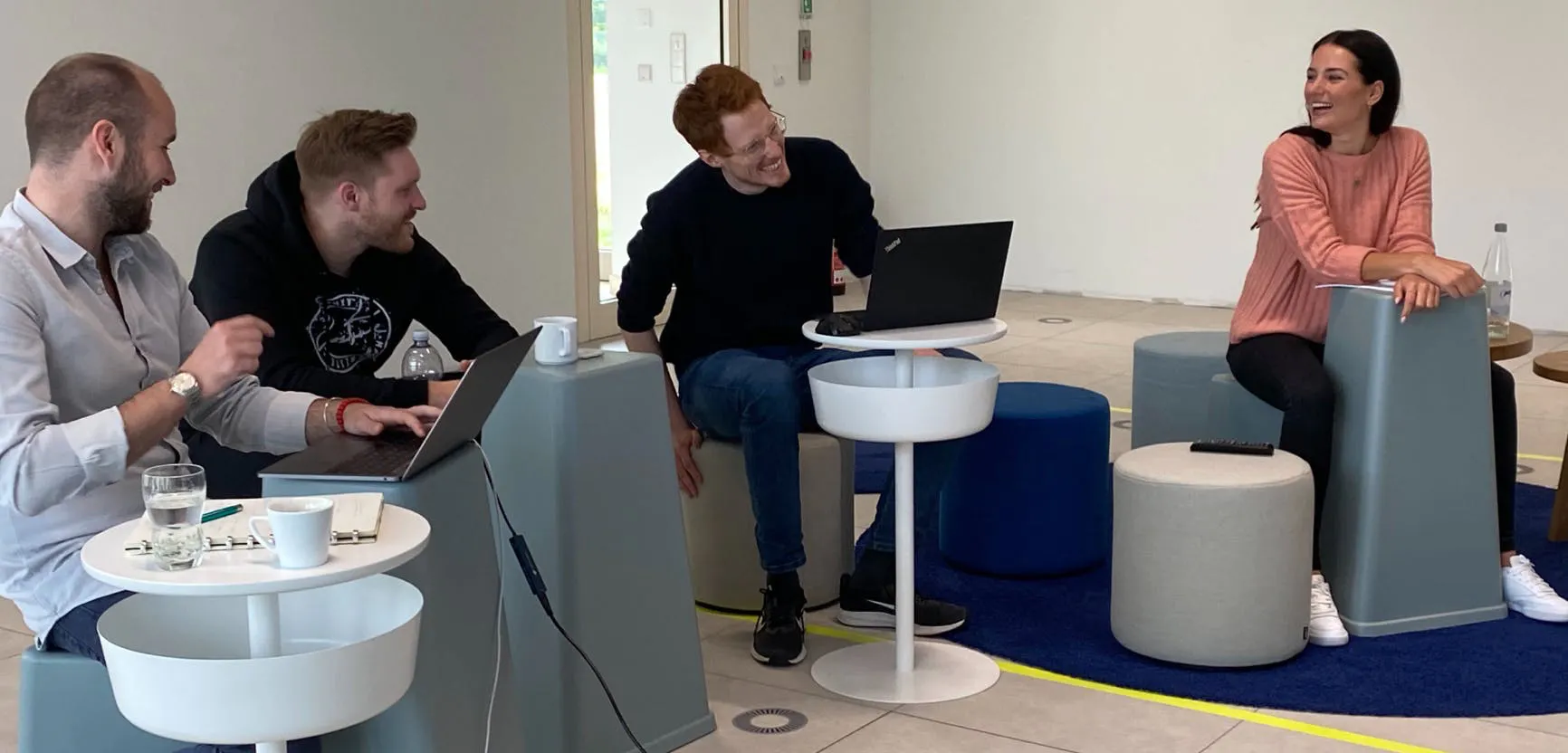 Four people sitting on chairs, laughing and debating