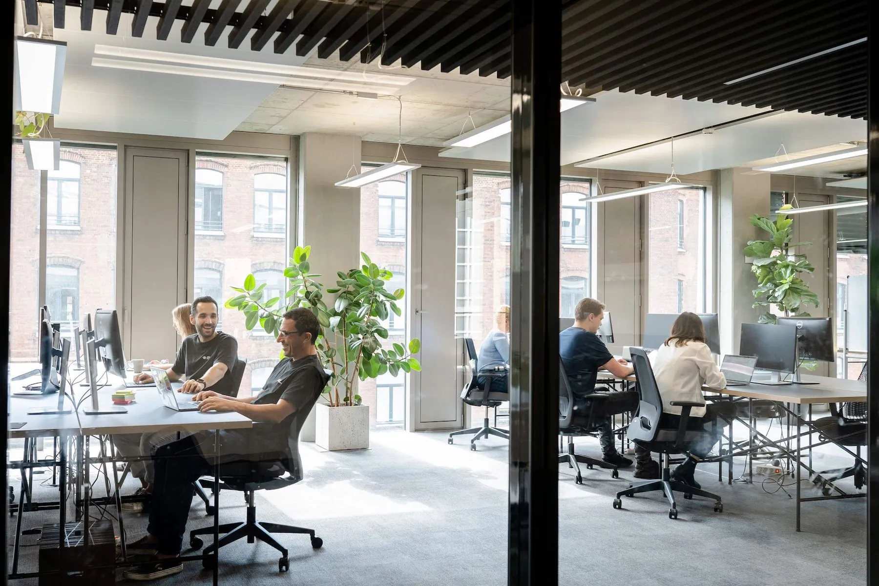Picture of team sitting around desks left and right talking to each other