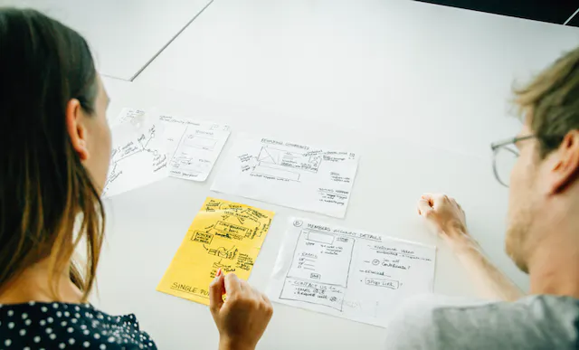 Man and woman looking at a hand drawn set of post notes