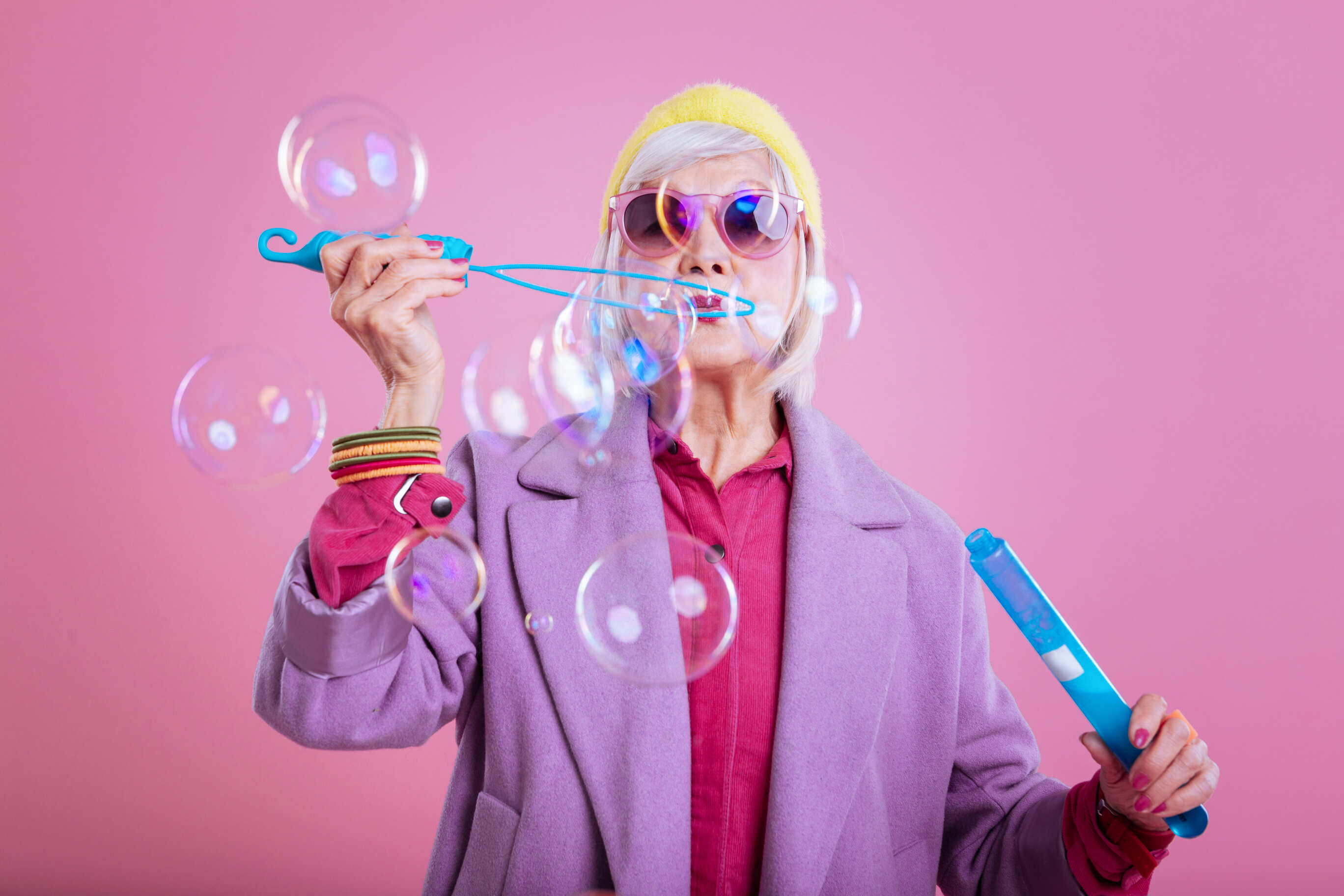 an image of an elderly lady blowing bubbles in a colourful outfit