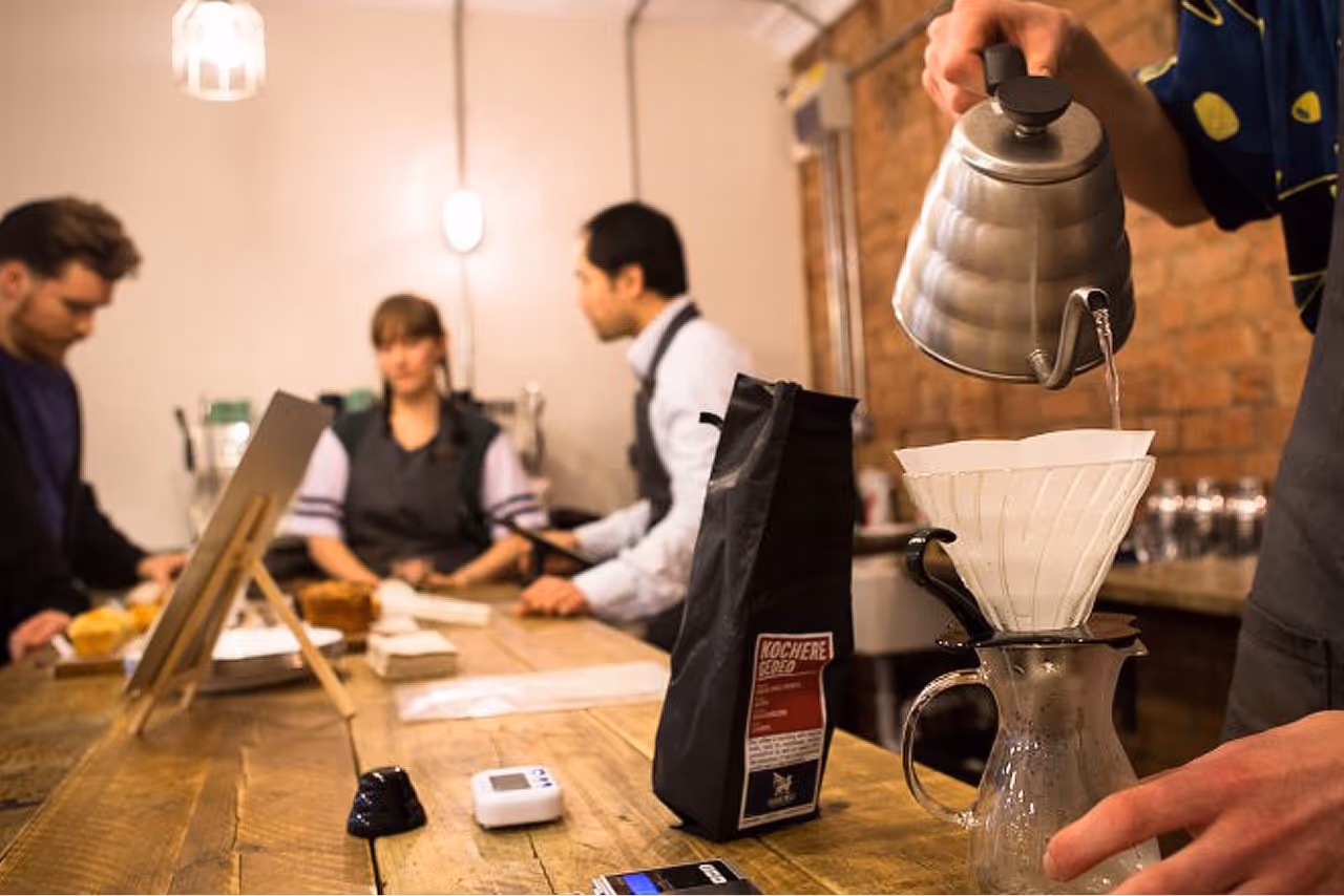 Person pouring filter coffee in a cafe