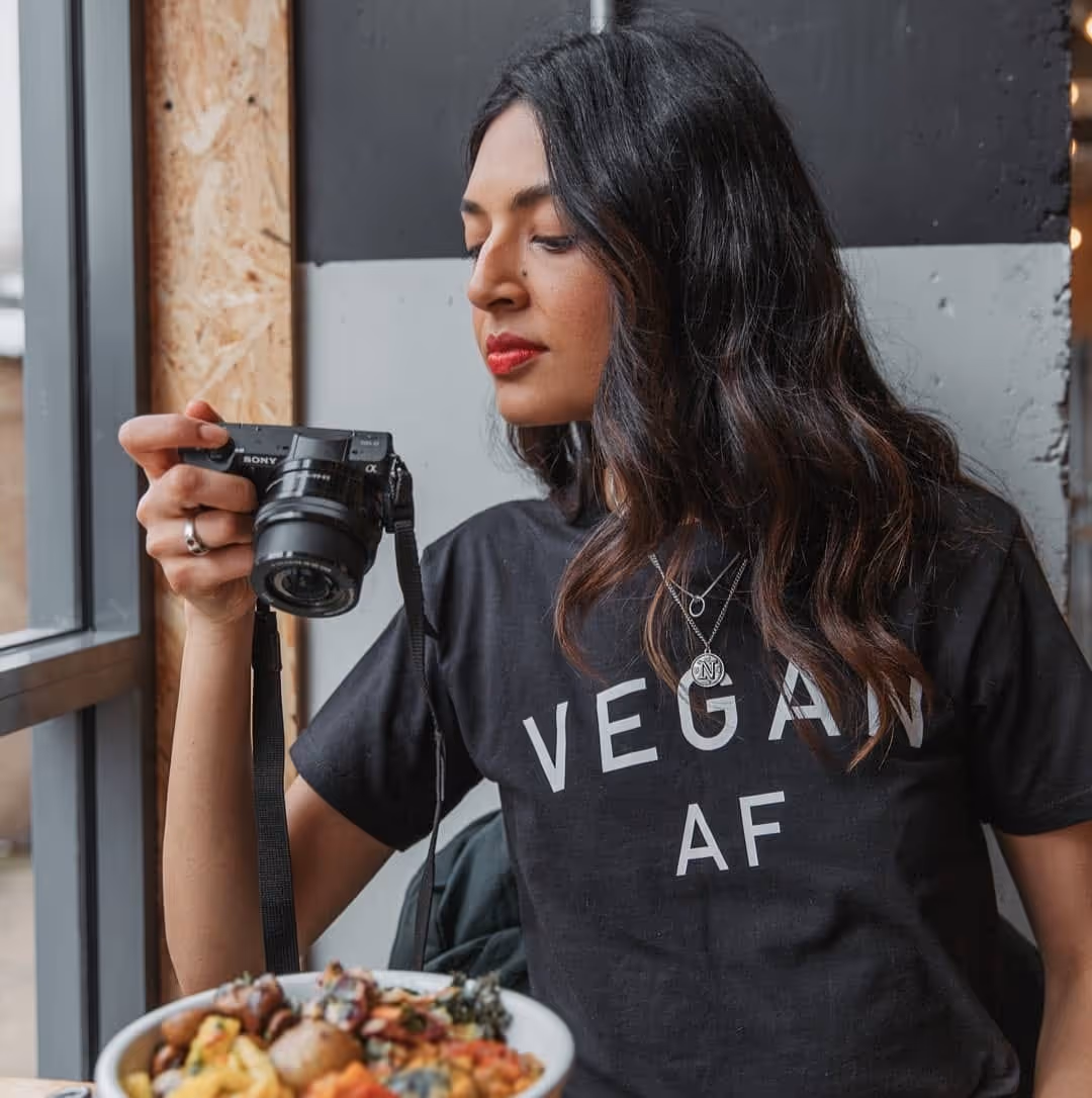 Tofu Tasha holding a camera above food
