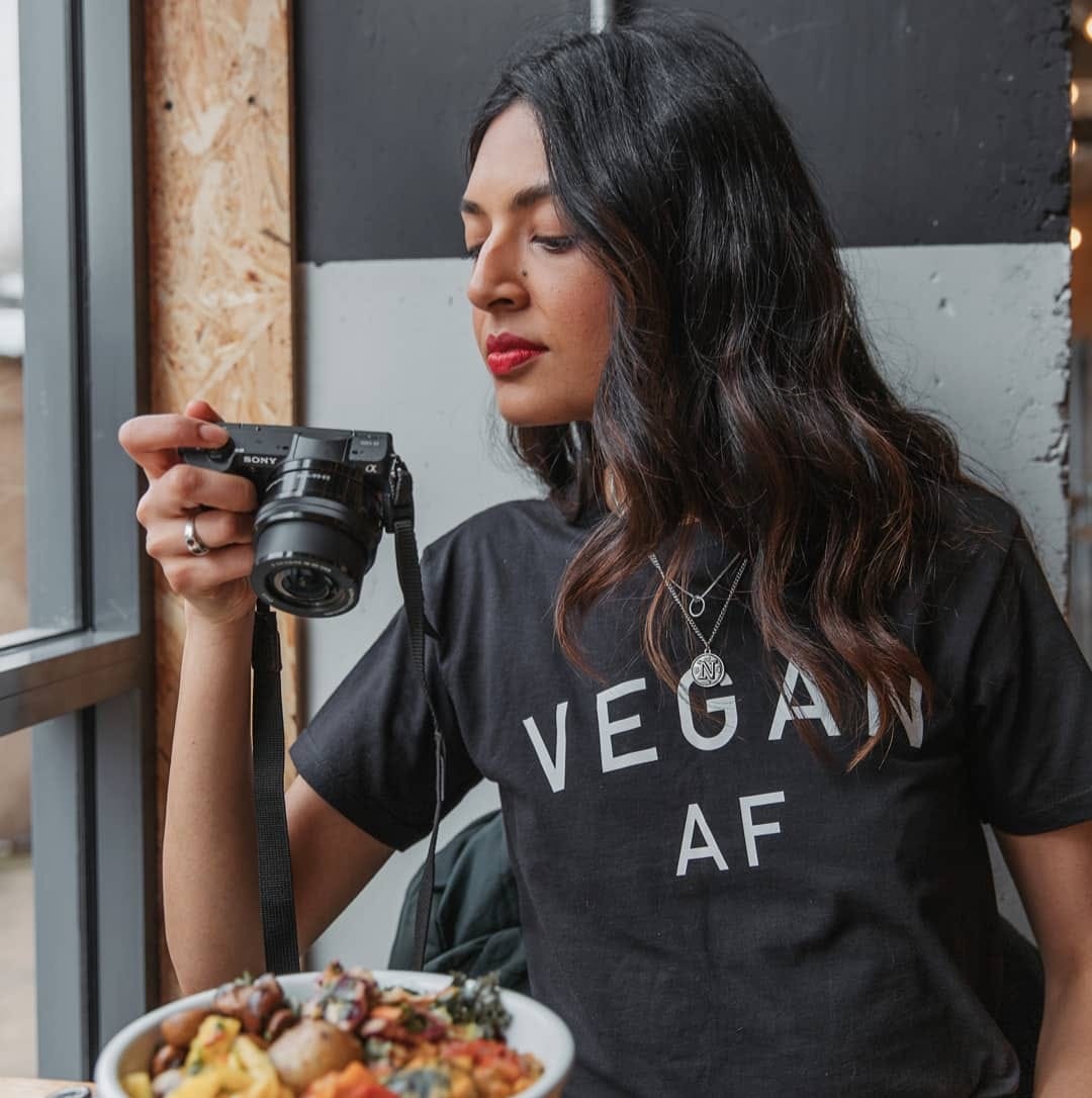 Tofu Tasha holding a camera above food