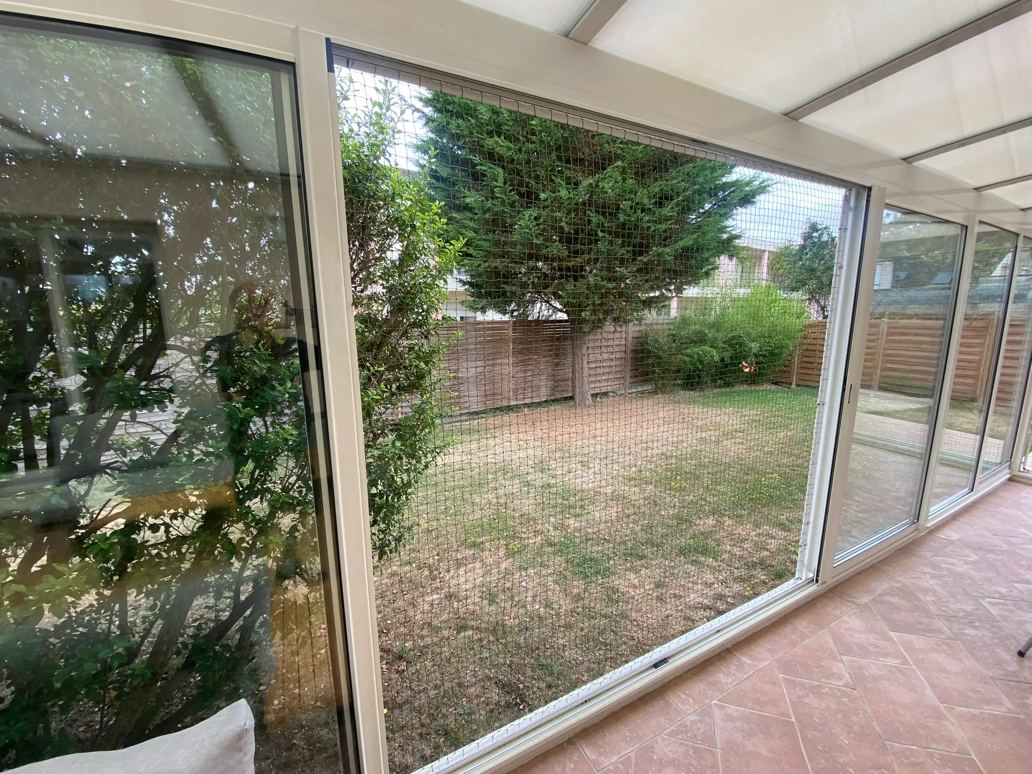 Baie vitrée équipée d’un cadre aluminium avec filet de protection pour chat