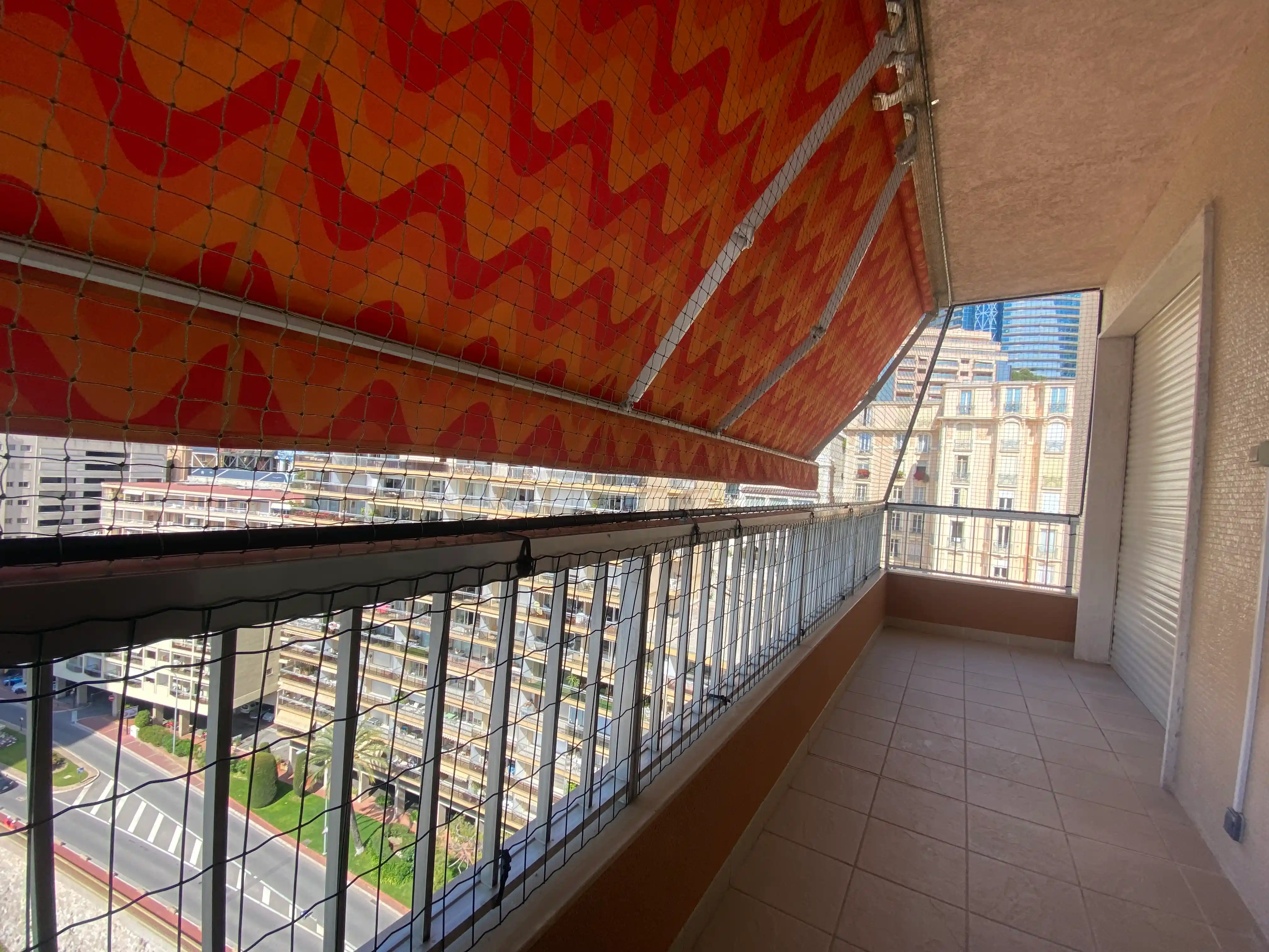 Balcon d’appartement avec un store protégé par un cadre avec filet de sécurité pour chat