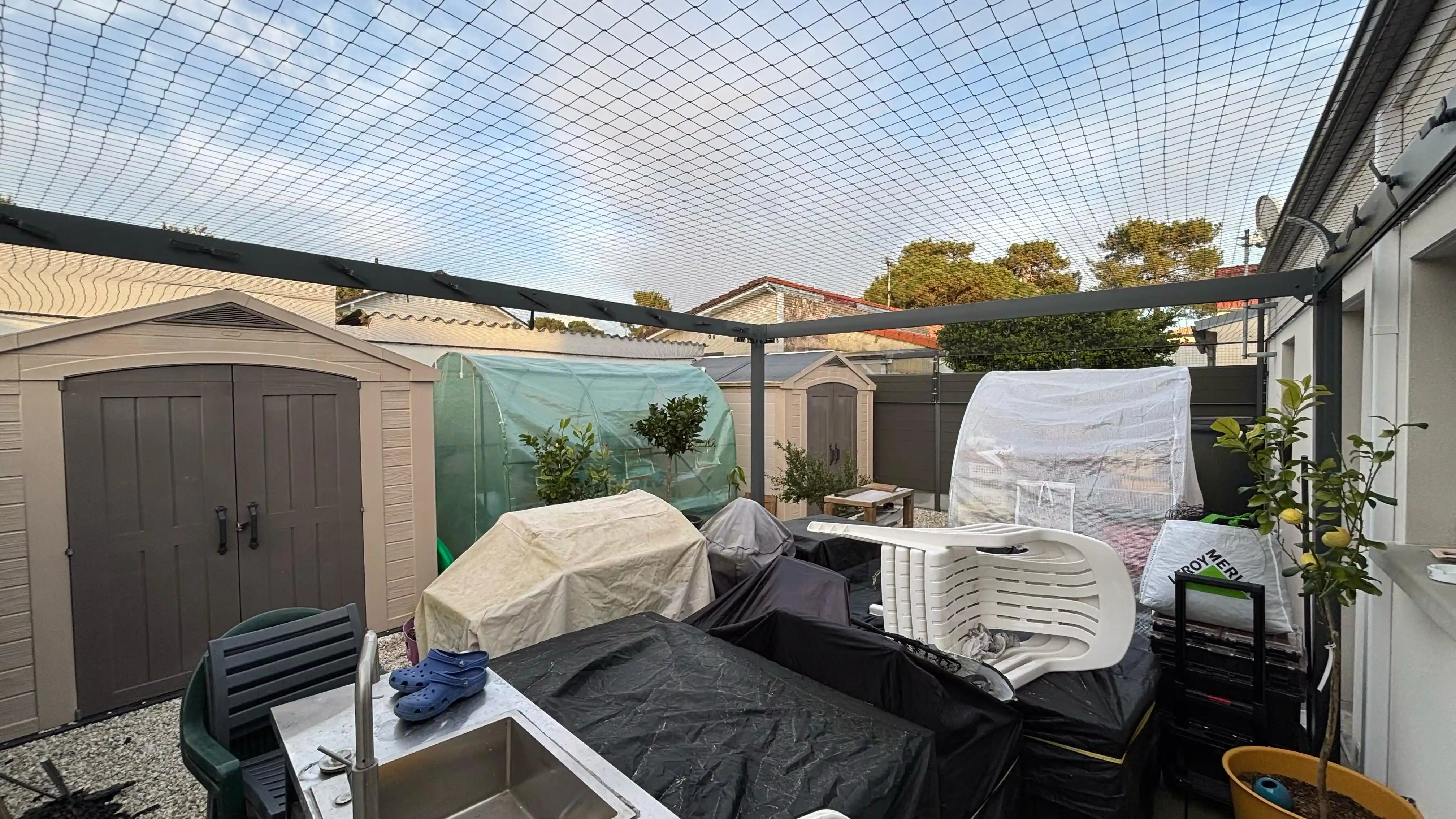 Grand filet aérien protégeant un jardin pour empêcher la fuite d’un chat