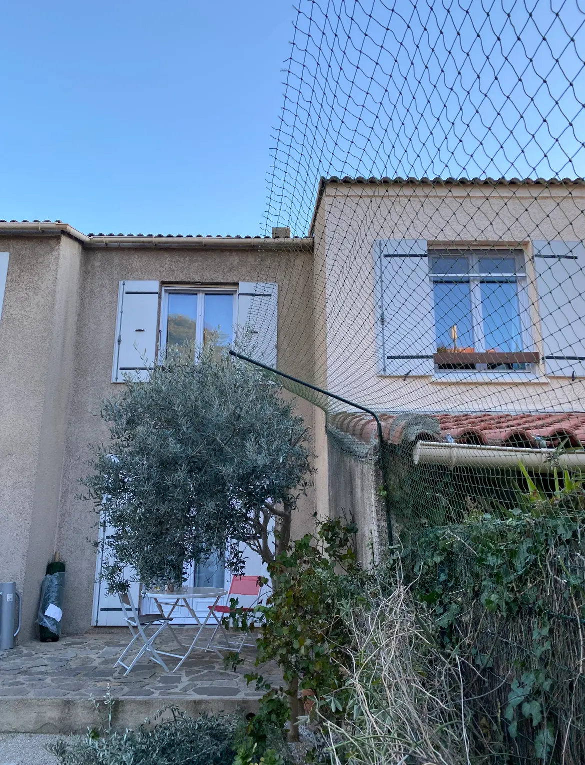 Bavolet anti fugue fixé sur une clôture grillagée pour chat