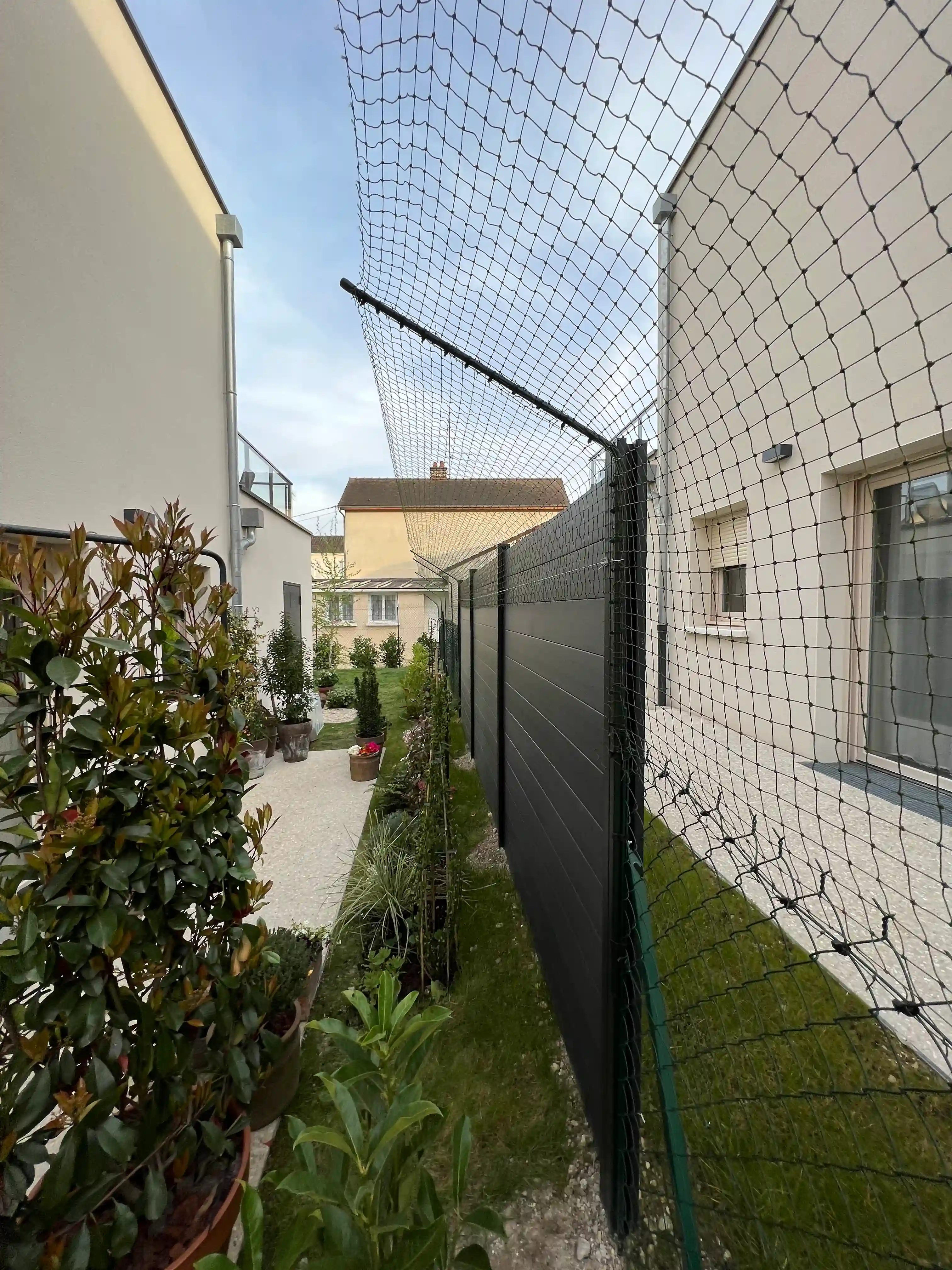 Bavolet anti fugue installé sur un grillage de jardin pour chat