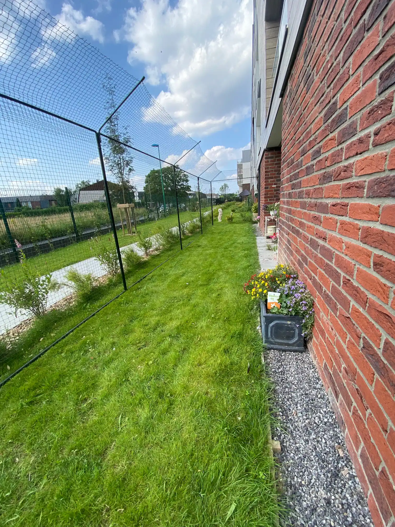 Système anti fugue pour chat installé sur une clôture de jardin